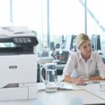 Deux femmes travaillant dans un bureau à côté d'une imprimante couleur multifonctions Xerox® VersaLink® C625