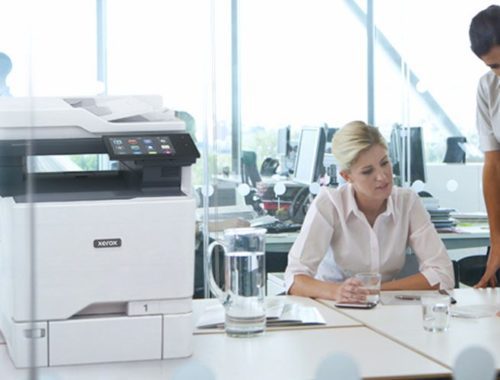 Deux femmes travaillant dans un bureau à côté d'une imprimante couleur multifonctions Xerox® VersaLink® C625